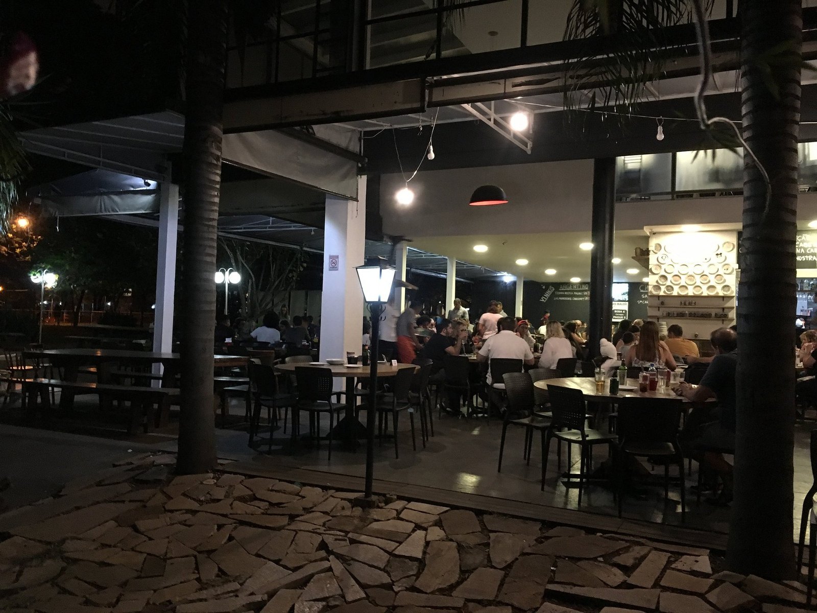 Área externa da Pizza à Bessa com mesas à noite